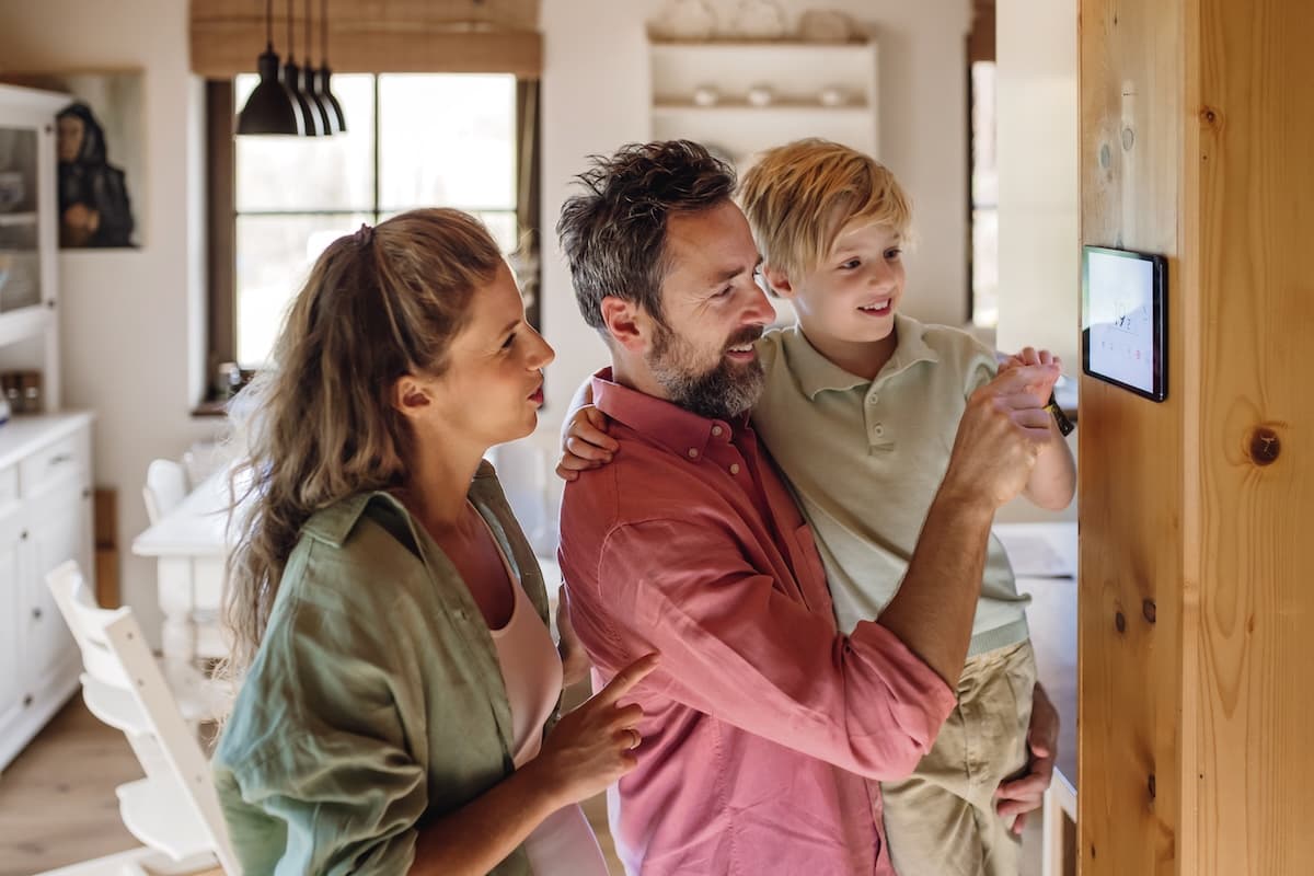 Family looking at smart thermostat